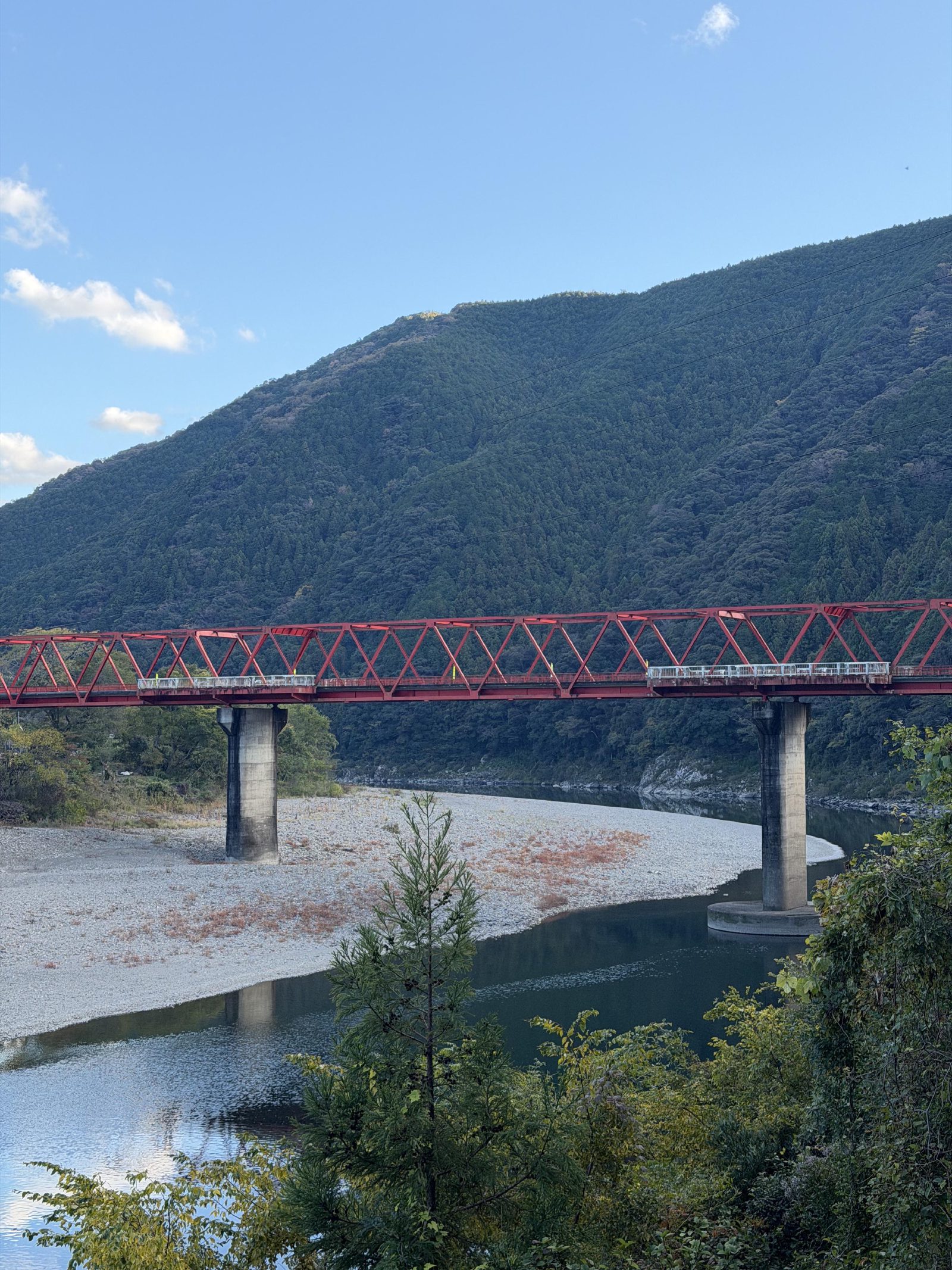 A red truss bridge spanning the river