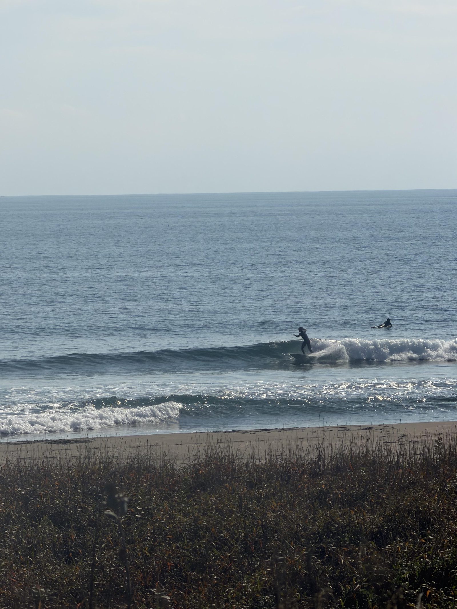 Surfers catching waves off the point