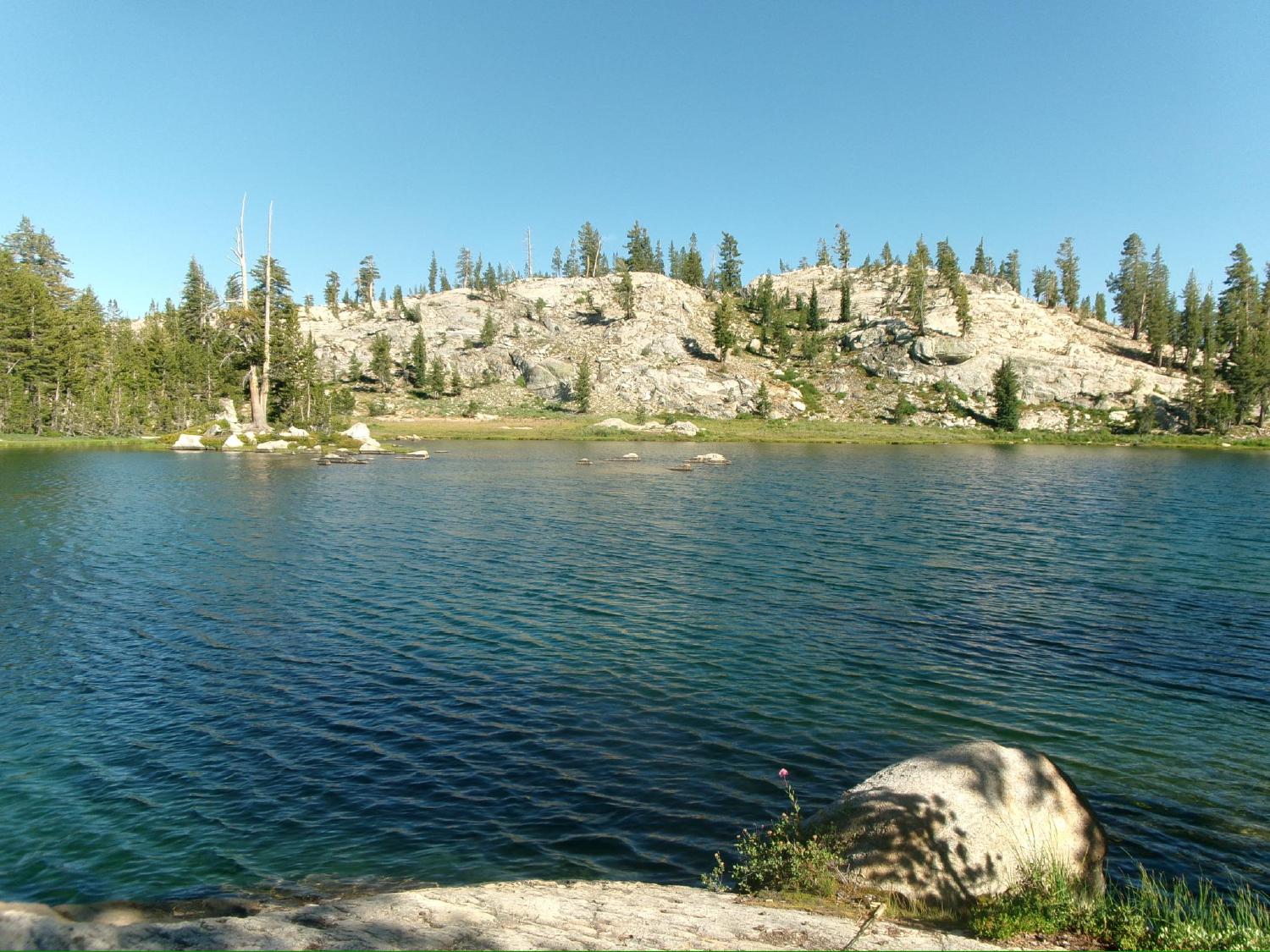 Toejam Lake with a granite dome and pines on the far shore